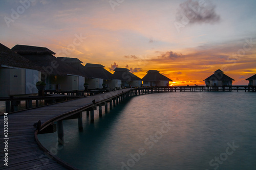 Sunset on tropical island  water villas resort