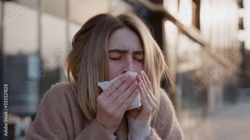 Close up view of sad young caucasian woman stand cough feel sick fever flu coronavirus covid 19 symptoms allergy city disease female nose lady runny tissue air pollution adult illness district