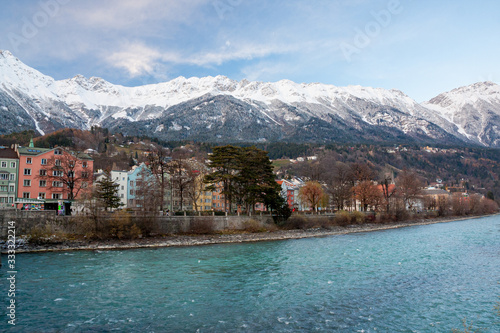 Colorful houses of the city of Innsbruck with river and snowy mountains © Mathia