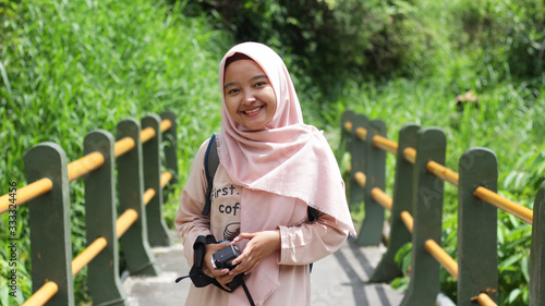 Hijab woman vacation wearing a pink dress and hijab at Kalikuning, Yogyakarta photo