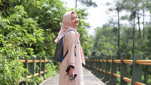 Hijab woman vacation wearing a pink dress and hijab at Kalikuning, Yogyakarta photo