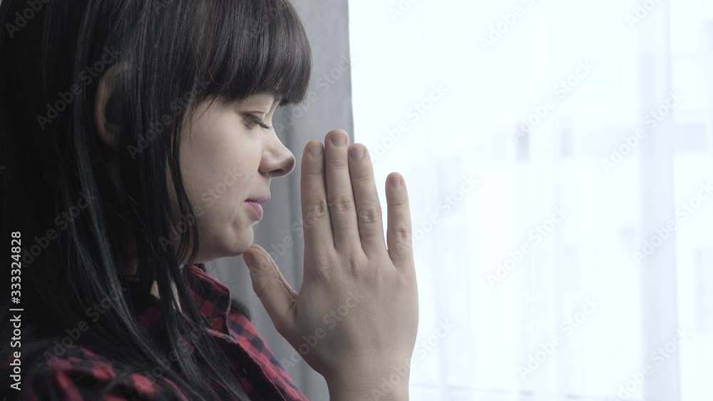 brunette girl makes a wish prayers bedtime religion concept. prayer woman mom lifestyle indoors praying by bed front of window brunette girl makes a wish prayers bedtime religion concept. prayer woman mom lifestyle indoors praying by bed front of window