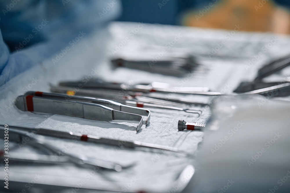 The surgeon's hands are holding an operating tool in the operating room. Close-up, beautiful light, modern medicine, Saving lives. The surgeon's hands are holding an operating tool in the operating room. Close-up, beautiful light, modern medicine, Saving lives.