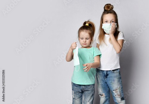 Two children girls kids are afraid of the disease in protection masks from the Coronavirus Covid-19 
