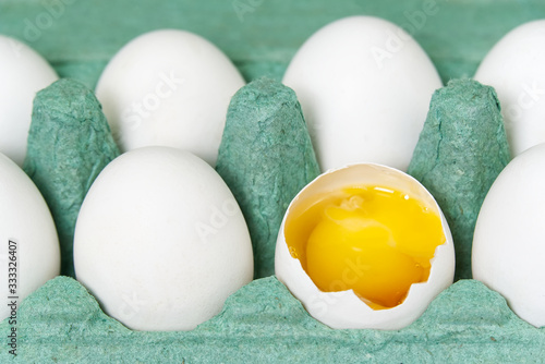 Green Paper Egg Tray with white eggs. chicken white eggs close up. broken chicken white egg.