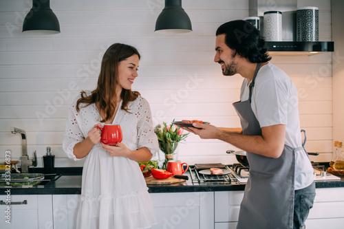International Women's Day. Young couple in the morning in the kitchen at home