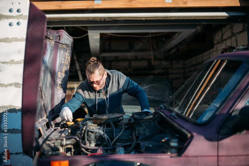 A man repairs a car, opens the hood A man repairs a car, opens the hood