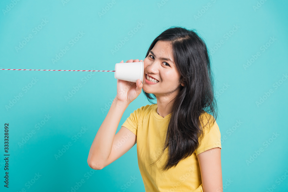 woman smile white teeth standing wear yellow t-shirt, She holding paper can telephone woman smile white teeth standing wear yellow t-shirt, She holding paper can telephone
