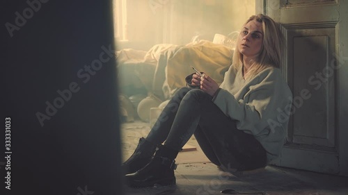 Addict woman with syringe in an abandoned house. Drug use, addiction, social degradation and self-destruction concept 