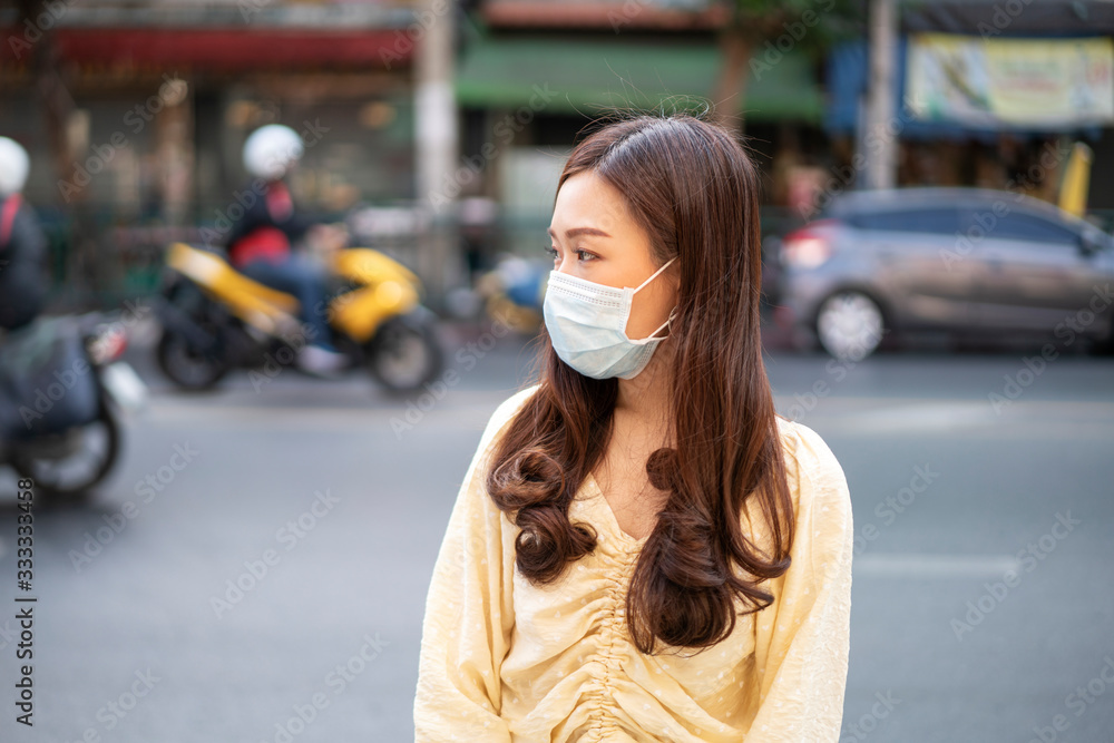 Asian beautiful woman wear protection mask for corona virus or covid-19 virus outbreak situation in a city. Corona virus, Covid-19, virus outbreak, PM 2.5 air pollution or social distancing concept