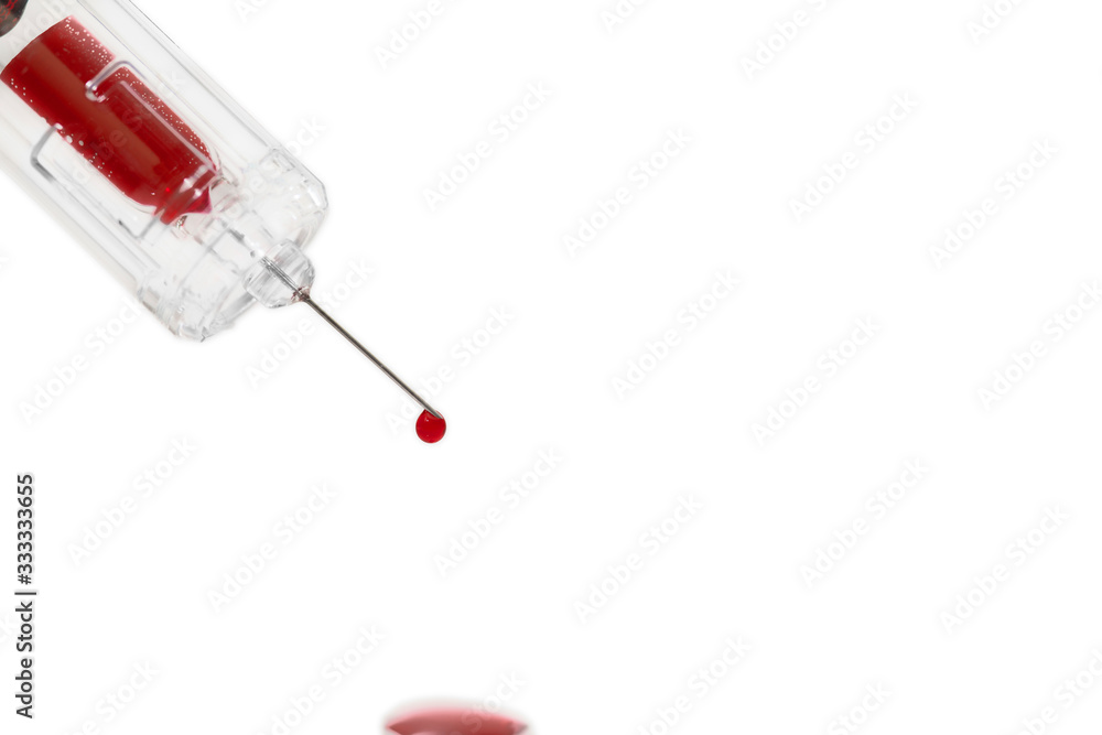syringe after a blood test. A drop of blood falls syringe after a blood test. A drop of blood falls