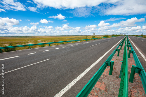 Empty highway, blue sky and white clouds landscape