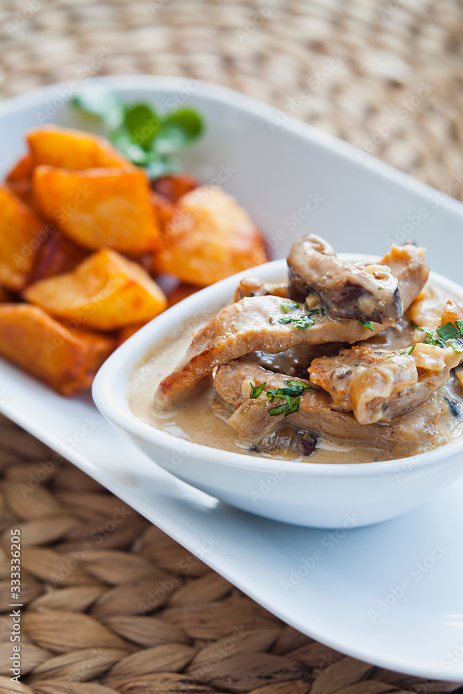 Sirloin pork stew with wild mushrooms, cream and garlic gravy . Served with fried potatoes and parsley as a tapas snack portion.