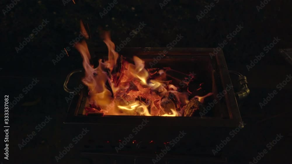 A barbeque at night. Man cooks vegetables on a grill A barbeque at night. Man cooks vegetables on a grill