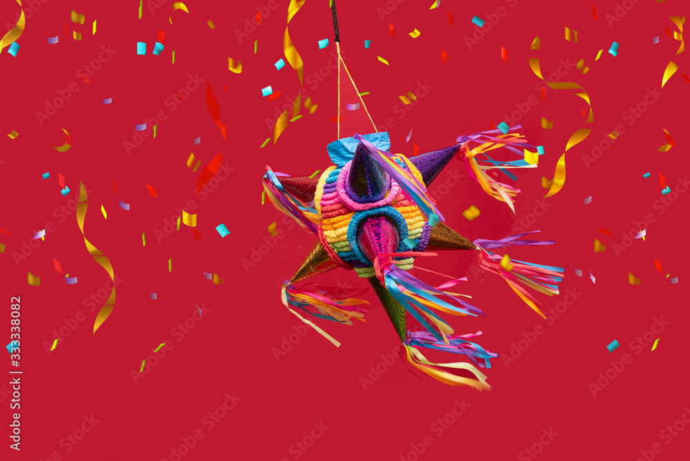 Fototapeta premium mexican piñata party hanging on purple and red background with multi-colored glitters celebrating birthday, christmas, party, party songs, figure in the shape of star and donkey, family fun