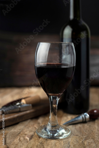 copa de vino tinto sobre fondo rustico y elegante destapador 