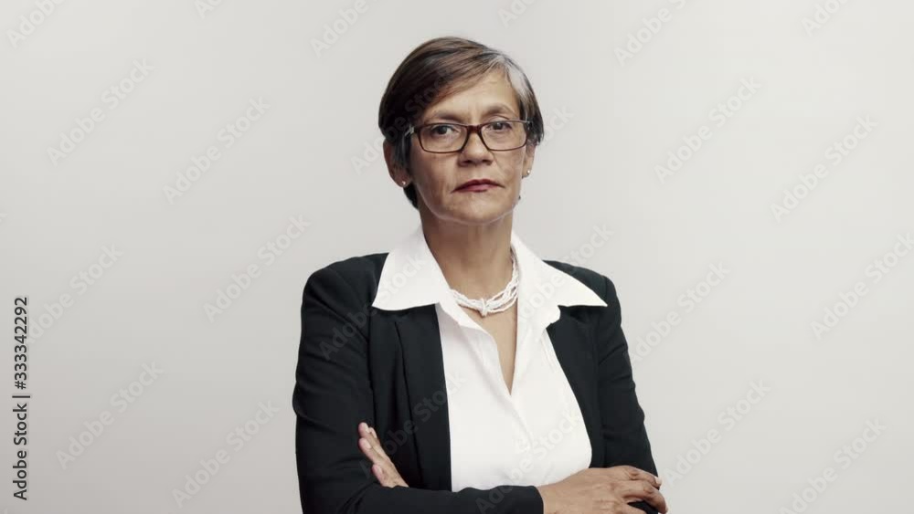 Senior businesswoman standing with her arms crossed. Female in formal wear on white background looking at camera. Senior businesswoman standing with her arms crossed. Female in formal wear on white background looking at camera.