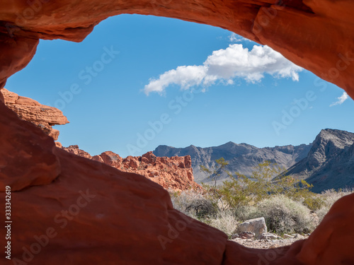 The desert view through a natural hole in red rock at Valley of Fire State Park  Nevada  USA.