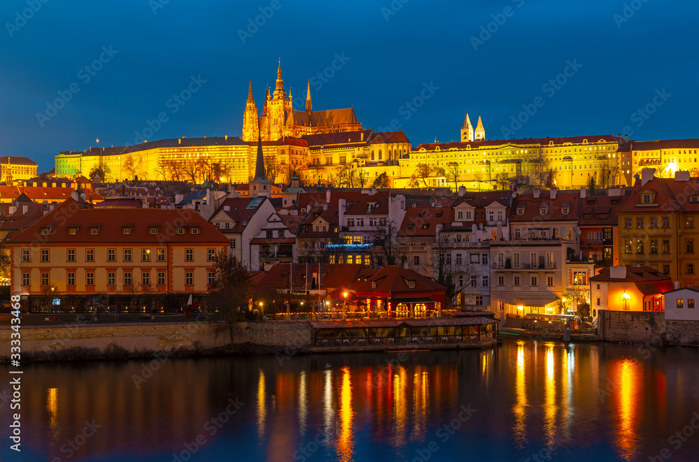 Prague Castle, also known as Hradcany Castle, at night along the Vltava river and the Saint Vitus cathedral on top, Czech Republic.