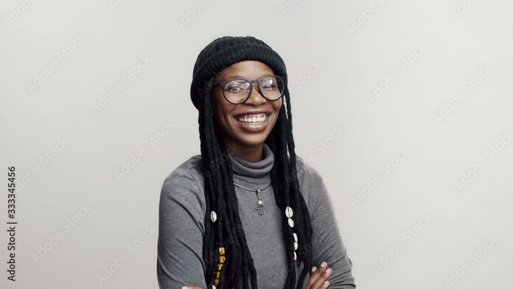 Happy african female having long dreadlocks looking at camera and smiling. Smiling african woman with her arms crossed on white background. Happy african female having long dreadlocks looking at camera and smiling. Smiling african woman with her arms crossed on white background.