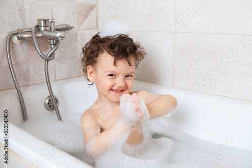 hygiene. the child bathes in a bath with foam. Occupation during coronavirus quarantine. Washing a child after a walk on the street. Disinfection and protection against dirt, germs and viruses.