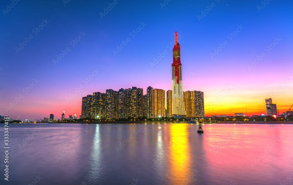Obraz premium Colorful sunset landscape in a riverside urban area with skyscrapers showing the most economic development in Ho Chi Minh City, Vietnam