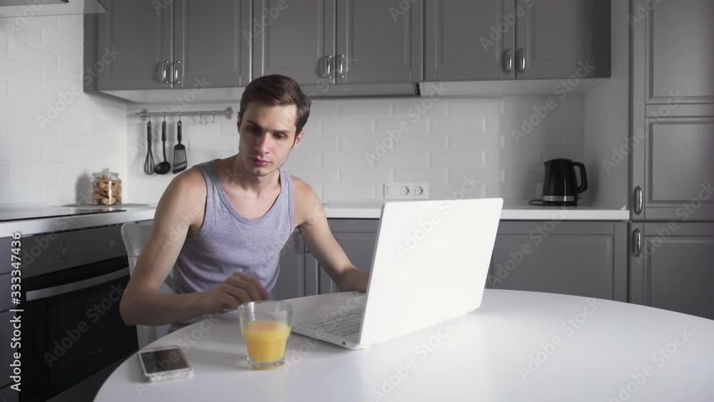 Young man working on laptop and using phone at home. Thoughtful business man Young man working on laptop and using phone at home. Thoughtful business man