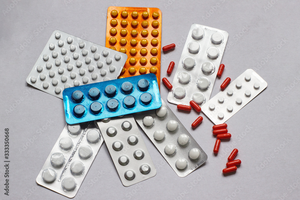 Set with various pills on white cardboard. Medical facilities. A pile of pills in blister packs. Close-up on a light background. Pharmaceutical blister pack. Set with various pills on white cardboard. Medical facilities. A pile of pills in blister packs. Close-up on a light background. Pharmaceutical blister pack.