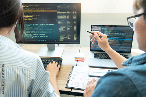 Obraz na płótnie Collaborative work Software engineers website developer technologies or programmer working coding on startup ai application project on screen with partner in coworking space office company.