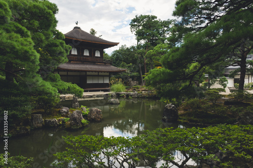 Historic Japanese Temple in a Calming Zen Forest Background with a Pond and Well Maintained Trees