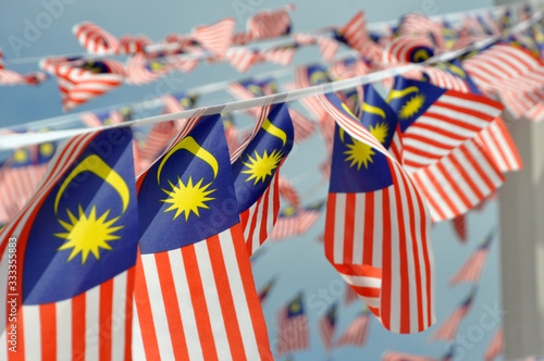 Selective focused on small size Malaysian flags tied together in large quantities. Fluttering in the wind.