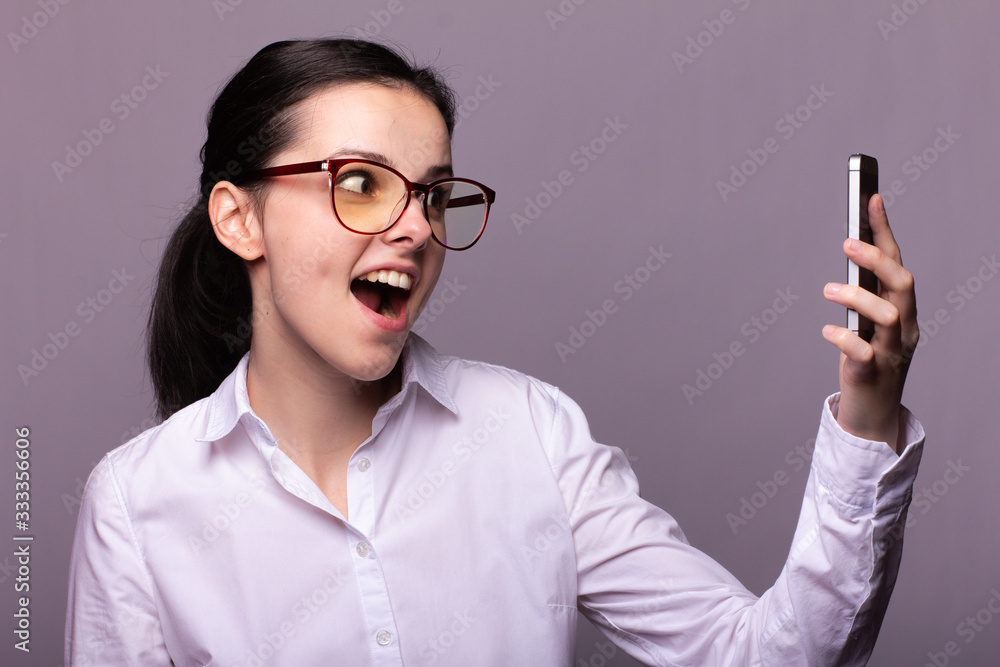 girl in a white shirt and glasses communicates on the phone girl in a white shirt and glasses communicates on the phone