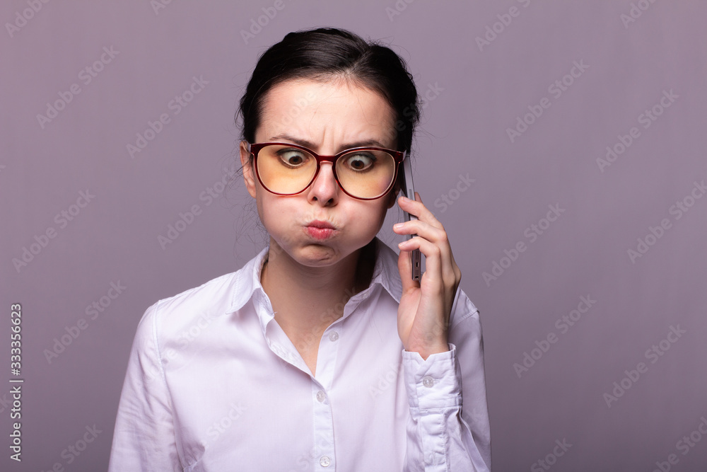girl in a white shirt and glasses communicates on the phone