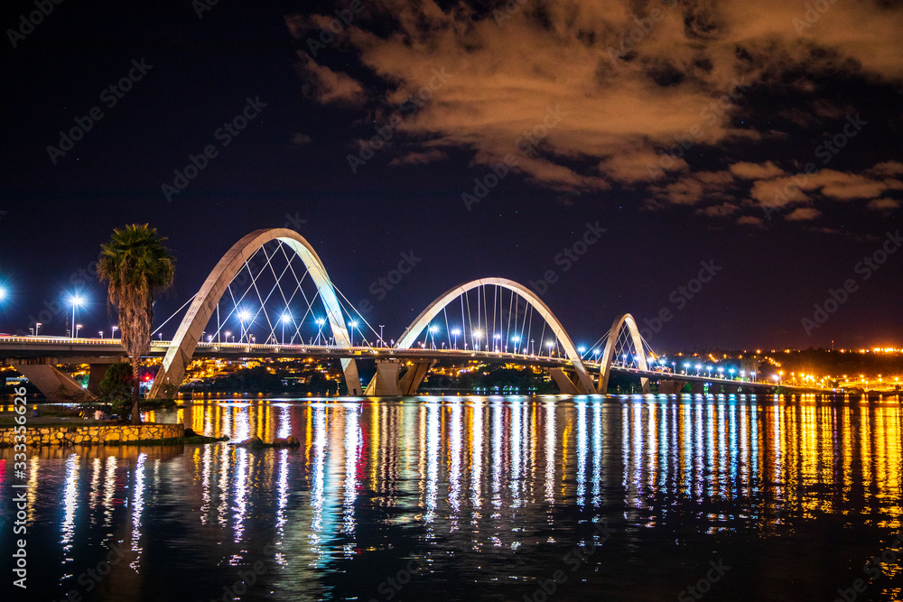 Fototapeta premium Cars race across the Juscelino Kubitschek Bridge just after sunset in Brasilia, Brazil.