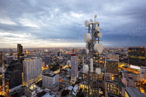 Telecommunication tower with 5G cellular network antenna on night city background