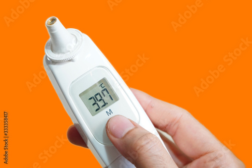 Electronic Electronic Thermometer with 39.7 Degree High Body Temperature COVID-19 Orange Background