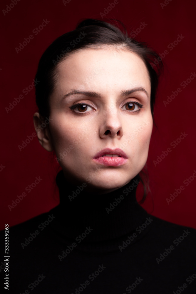emotional girl in a black turtleneck on a red background emotional girl in a black turtleneck on a red background