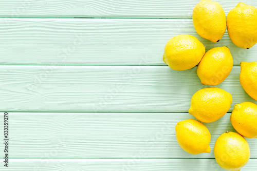 Lemons frame - whole fruits - on green wooden table top-down copy space