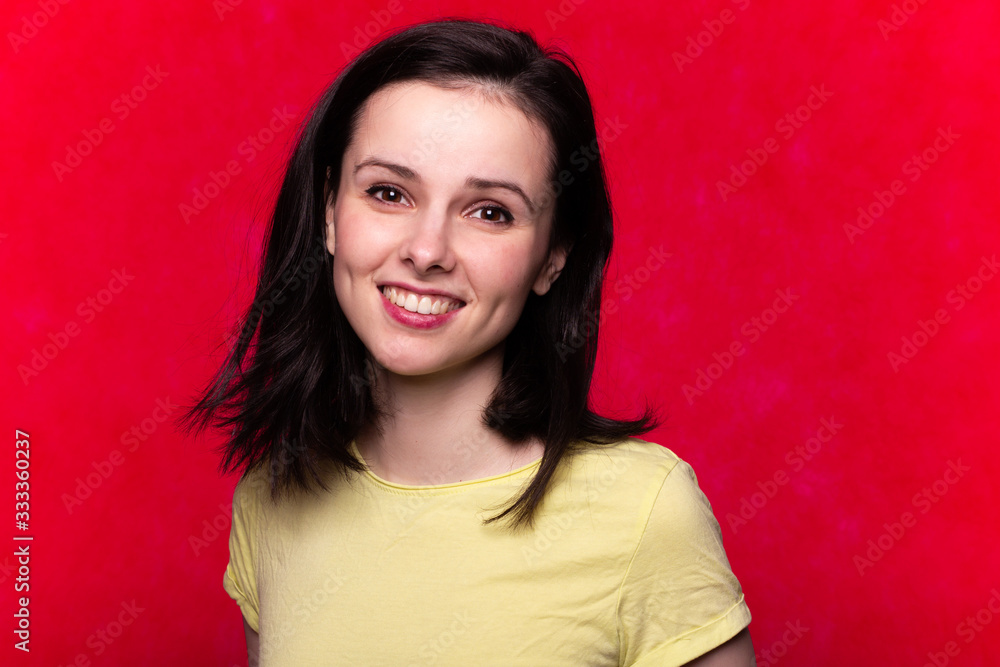 beautiful girl in a yellow t-shirt on a red background beautiful girl in a yellow t-shirt on a red background