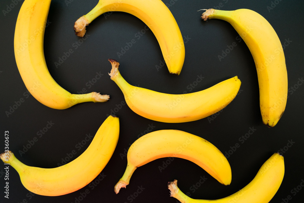  Background of yellow bananas on a black background.