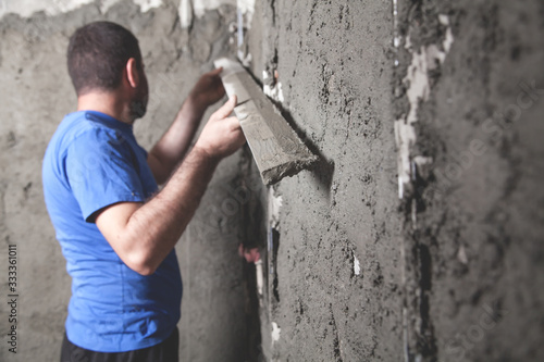 Worker holding level tool. Plastering wall. Construction work