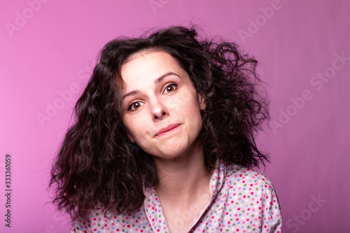 beautiful curly girl in pajamas, pink background