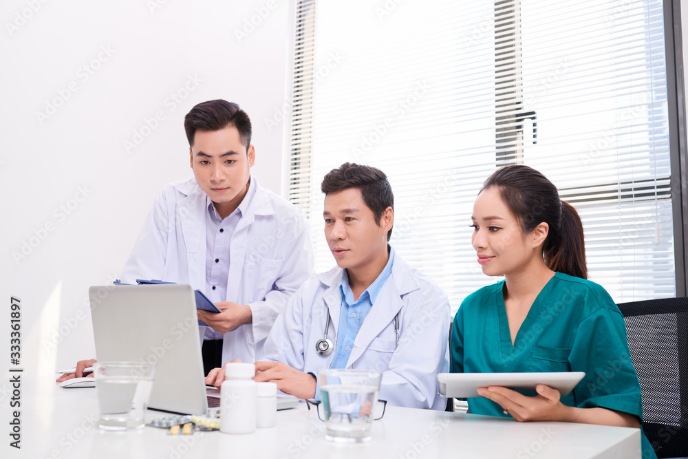 Doctor team working at computer desk in hospital Doctor team working at computer desk in hospital
