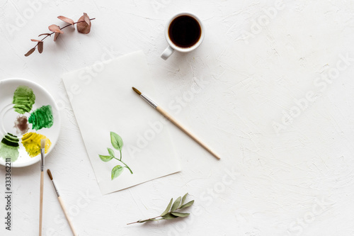 Painting herbs. Brushes and picture on white wooden background top-down copy space