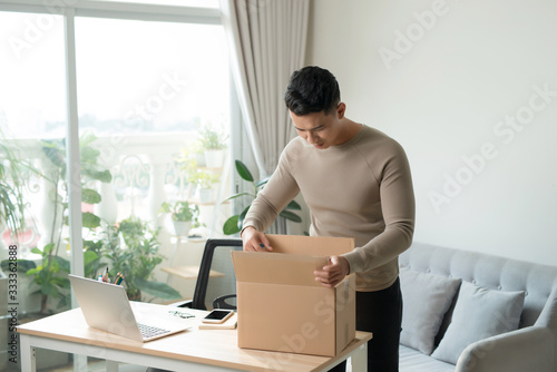 Young man unpacking received parcel
