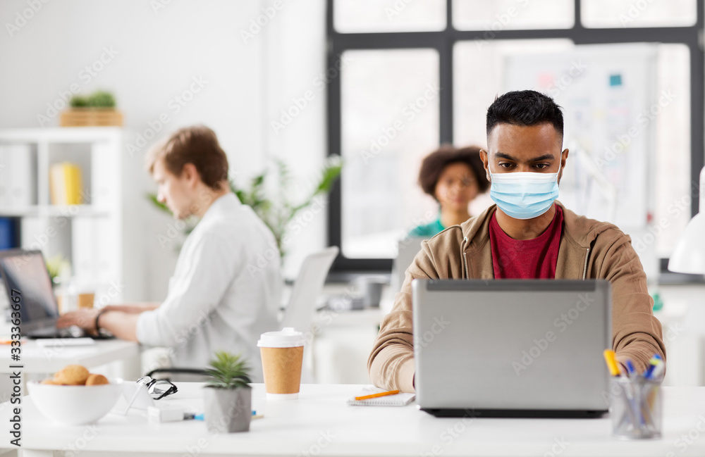 business and creative people concept - young indian man with laptop computer wearing protective medical mask for protection from virus disease working at office business and creative people concept - young indian man with laptop computer wearing protective medical mask for protection from virus disease working at office