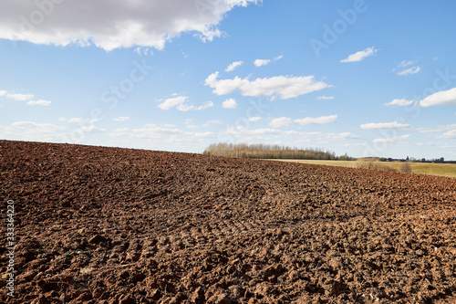 Panorama of arable land and blue sky with white clouds in a sunny day