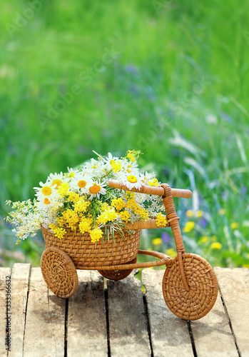 bouquet of meadow flowers in retro wicker rattan Bicycle. beautiful rustic summer scene. copy space
