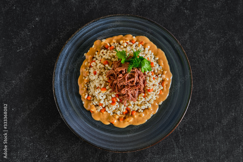Top view of pulled beef with pearl barley and creamy sauce Top view of pulled beef with pearl barley and creamy sauce