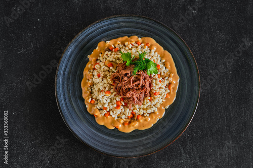 Top view of pulled beef with pearl barley and creamy sauce